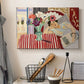 Canvas art print detailing a stylized composition with figure and decorative textiles, displayed in a softly lit workspace setting