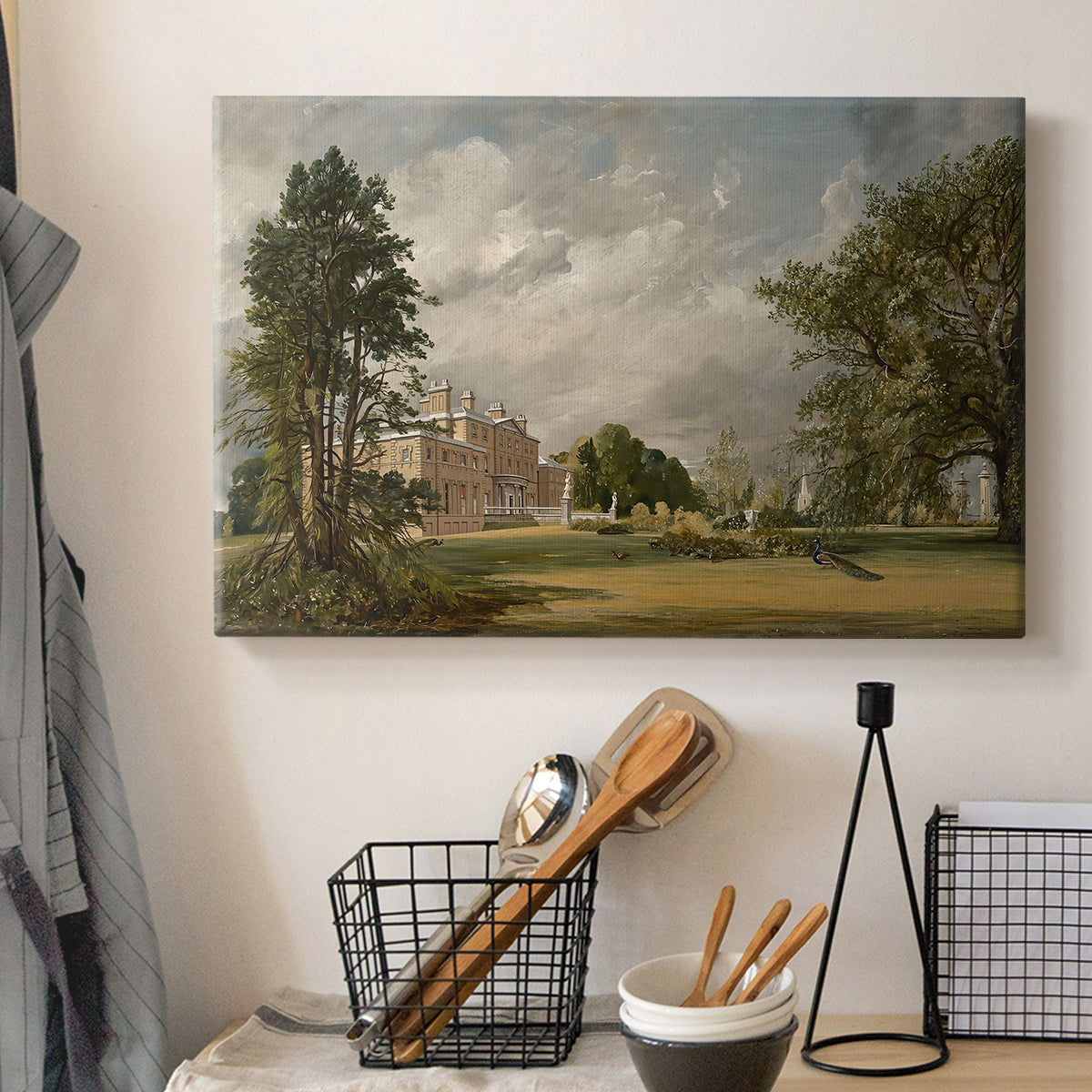 Canvas art print detailing a countryside view with house and vegetation, displayed in a softly lit workspace setting