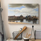 Canvas art print detailing a panoramic town scene with skyline, displayed in a softly lit workspace setting