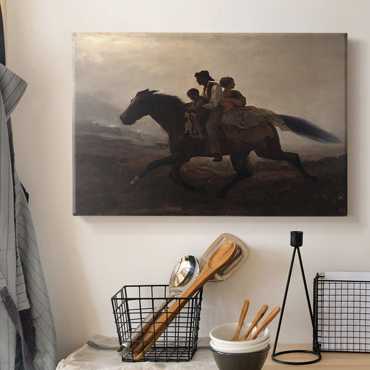 Canvas art print detailing figures on horse moving swiftly through shadowy landscape, displayed in a softly lit workspace setting