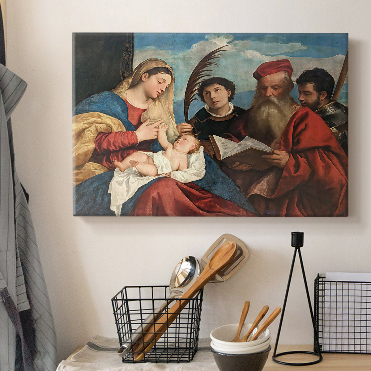 Canvas art print detailing a devotional composition with multiple saints surrounding central pair, displayed in a softly lit workspace setting