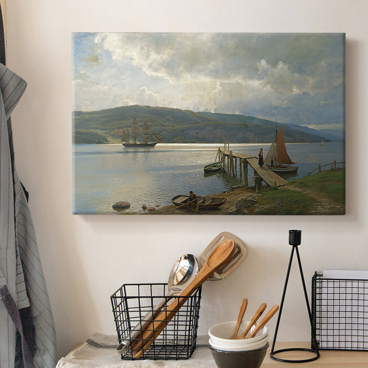 Canvas art print detailing a seaside setting with jetty and quiet water, displayed in a softly lit workspace setting