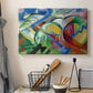 Canvas art print detailing a simplified animal forms arranged within vibrant abstract scene, displayed in a softly lit workspace setting