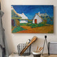 Canvas art print detailing a stylized cityscape with cottages and sky, displayed in a softly lit workspace setting