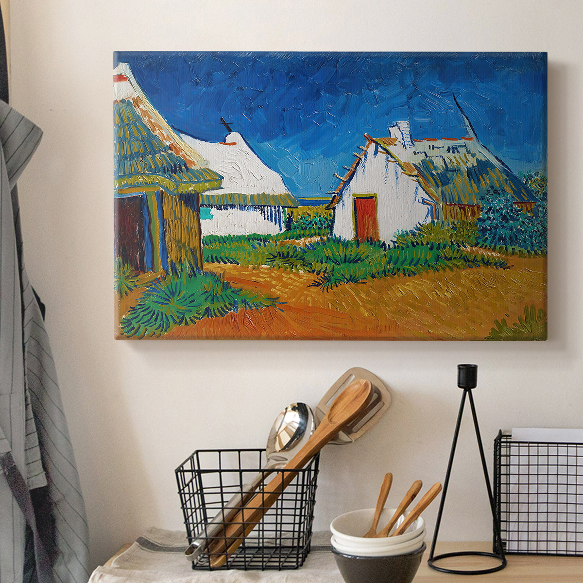 Canvas art print detailing a stylized cityscape with cottages and sky, displayed in a softly lit workspace setting