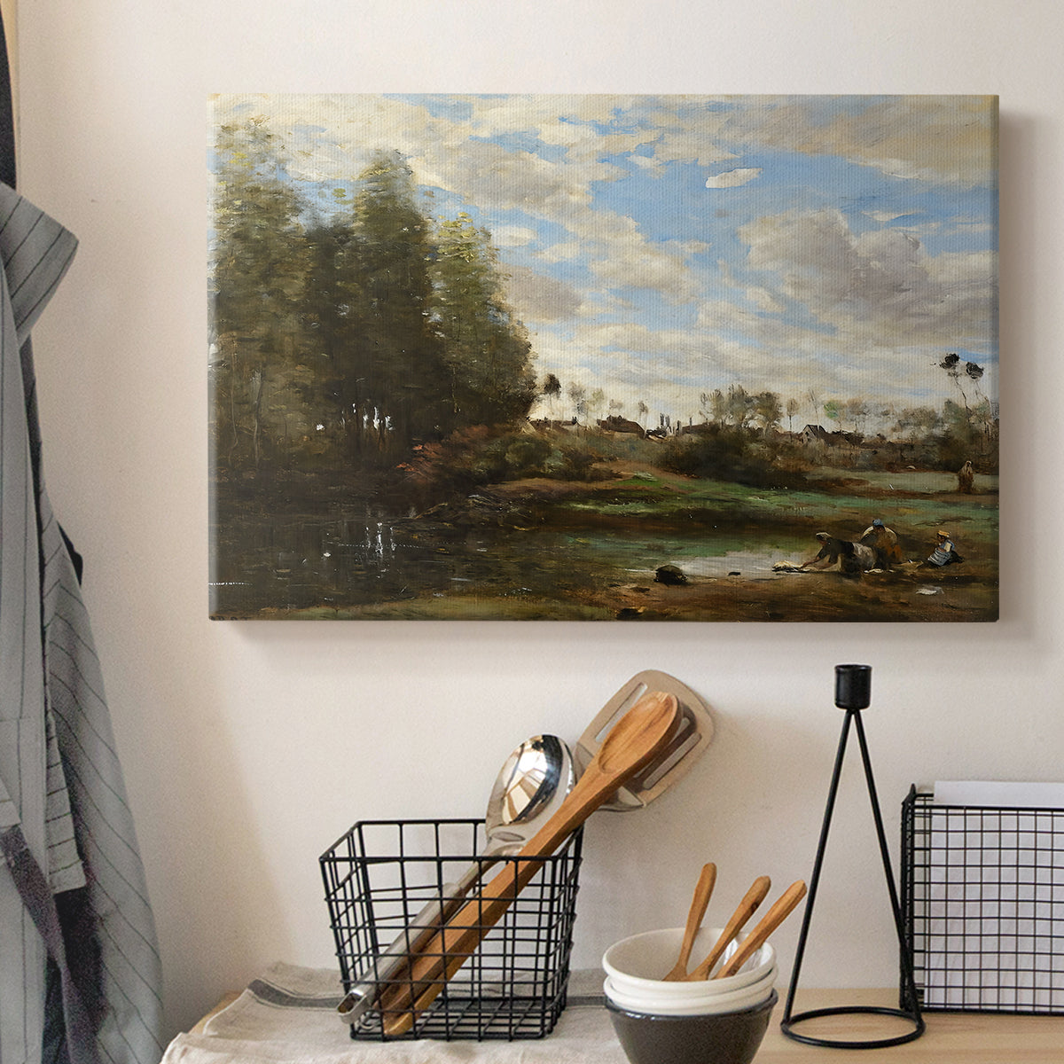 Canvas art print detailing a tranquil outdoor setting with washerwomen and river, displayed in a softly lit workspace setting
