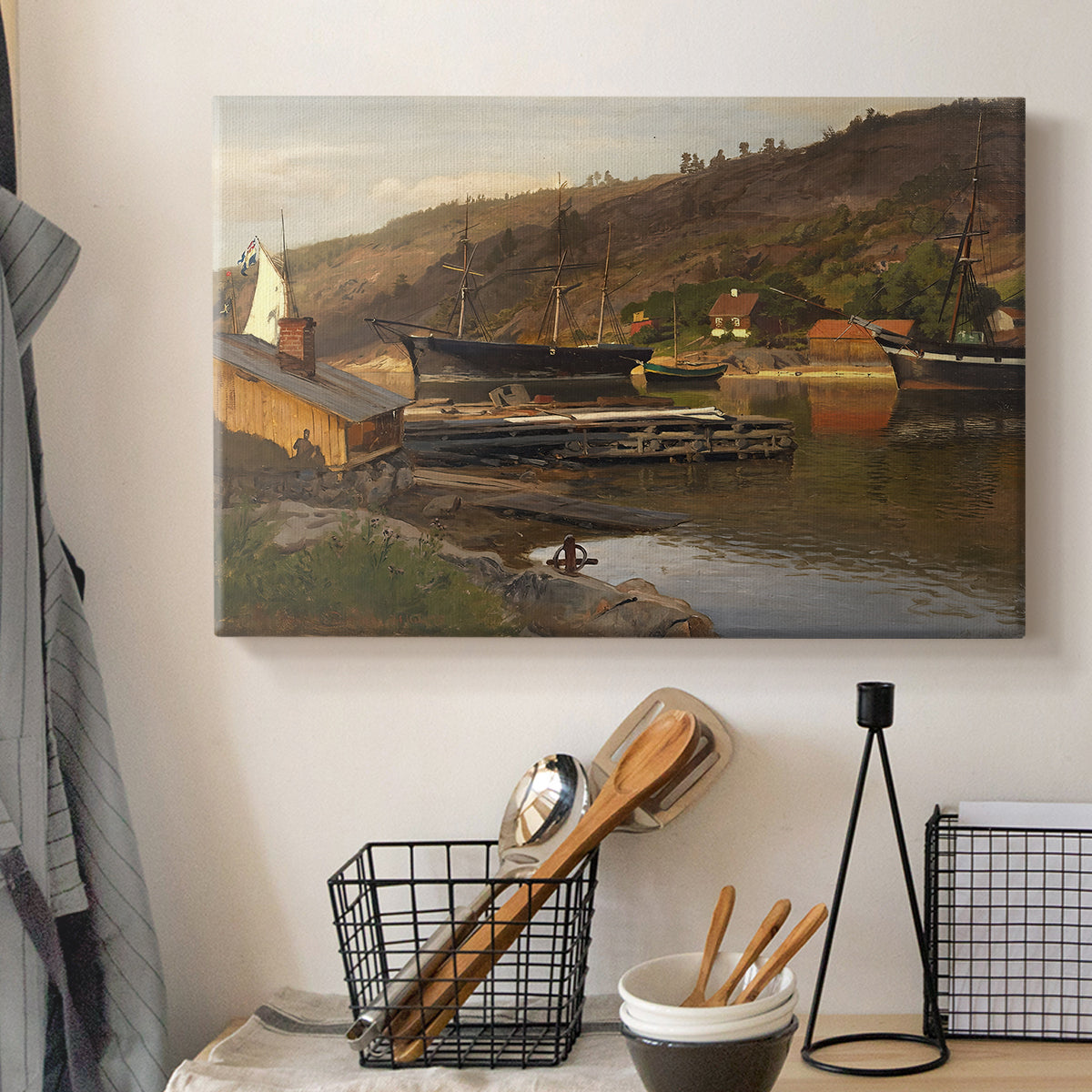 Canvas art print detailing a tranquil harbor landscape with nautical activity, displayed in a softly lit workspace setting