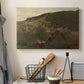 Canvas art print detailing a romantic landscape with depth and layered hills, displayed in a softly lit workspace setting