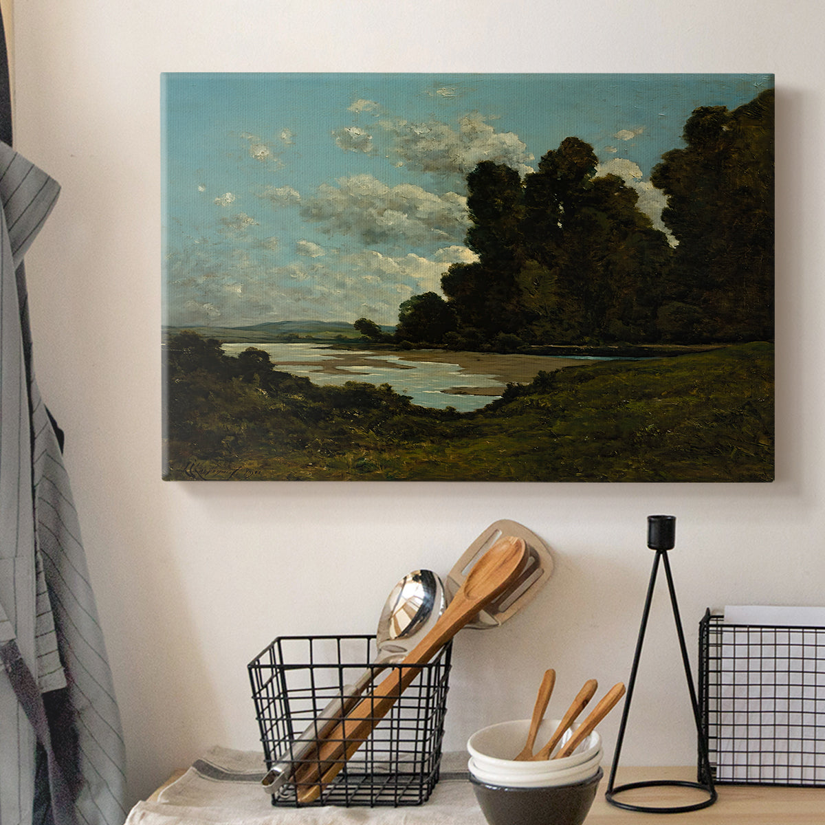 Canvas art print detailing an expansive landscape with river and built environment, displayed in a softly lit workspace setting