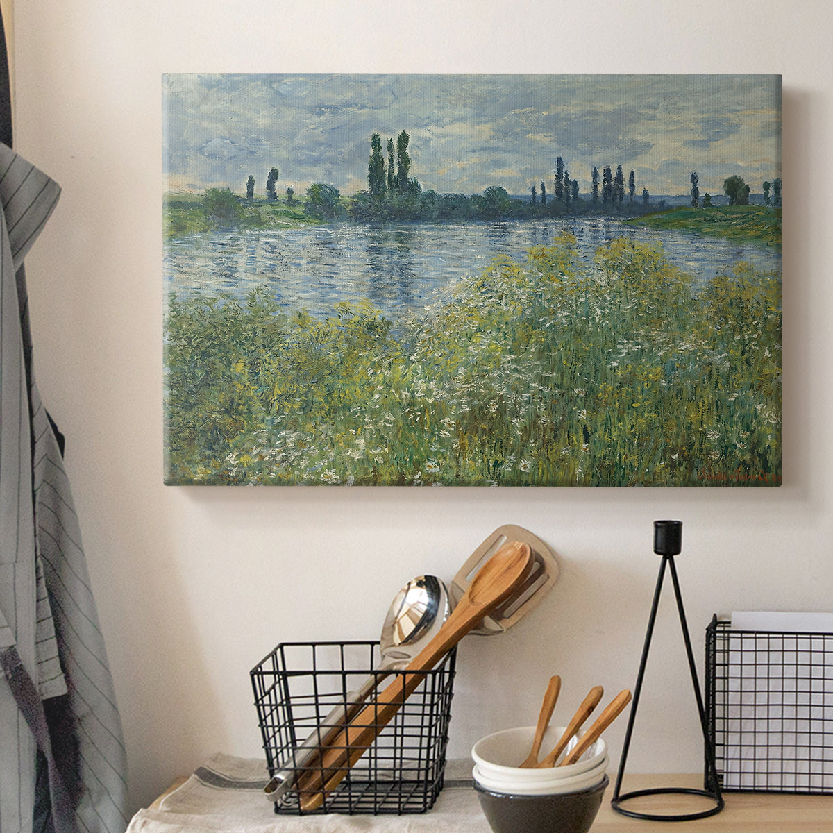 Canvas art print detailing a natural landscape with calm water and soft foliage, displayed in a softly lit workspace setting