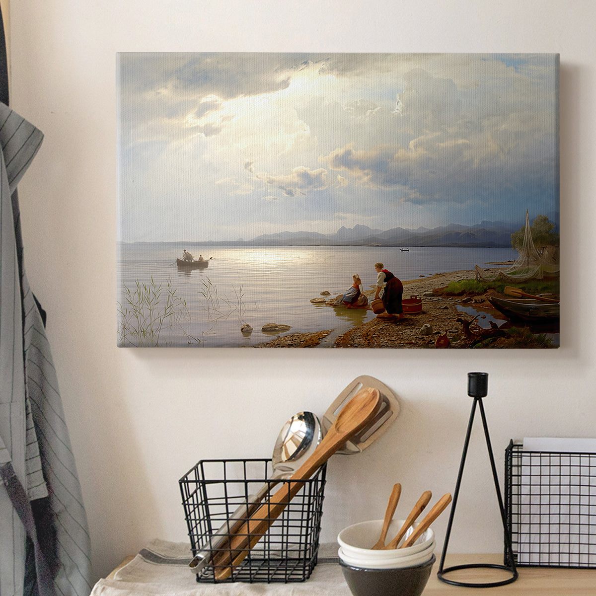 Canvas art print detailing a calm landscape with shoreline activity and soft sky, displayed in a softly lit workspace setting