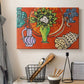 Canvas art print detailing a stylized still life featuring magnolia blossoms, displayed in a softly lit workspace setting