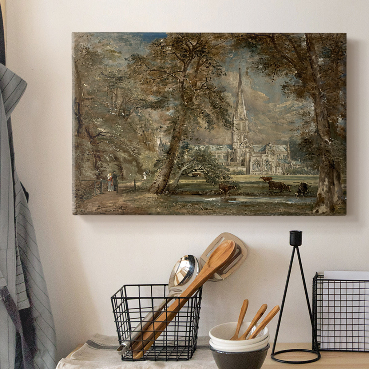 Canvas art print detailing a landscape featuring cathedral and greenery, displayed in a softly lit workspace setting