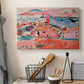 Canvas art print detailing a stylized coastal settlement with architecture and water, displayed in a softly lit workspace setting