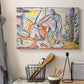 Canvas art print detailing a stylized outdoor composition of figures by the coast, displayed in a softly lit workspace setting