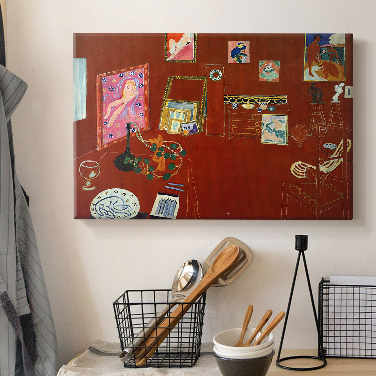 Canvas art print detailing a stylized artist studio dominated by red, displayed in a softly lit workspace setting