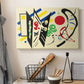 Canvas art print detailing a stylized composition with shapes and directional movement, displayed in a softly lit workspace setting