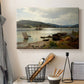 Canvas art print detailing a serene shoreline view with boats and human presence, displayed in a softly lit workspace setting