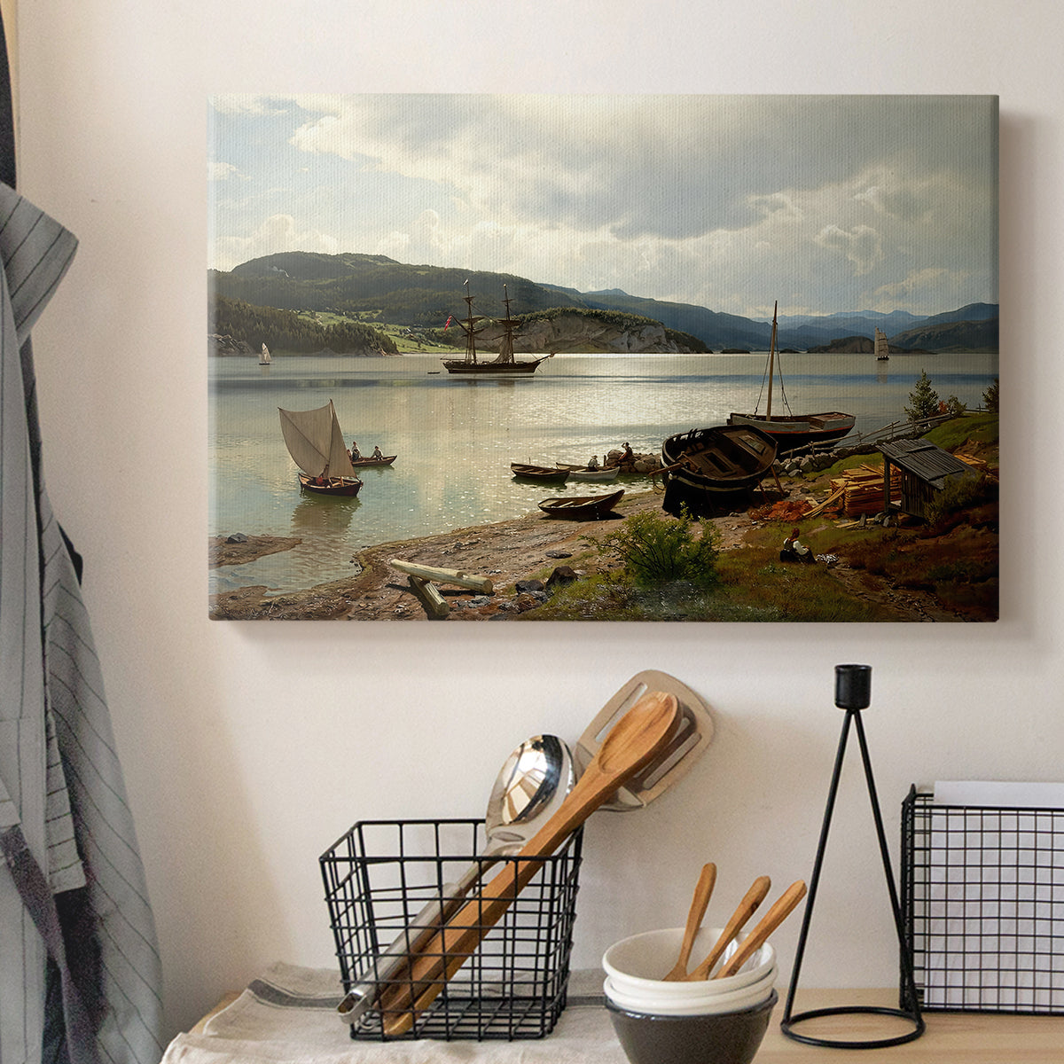 Canvas art print detailing a serene shoreline view with boats and human presence, displayed in a softly lit workspace setting