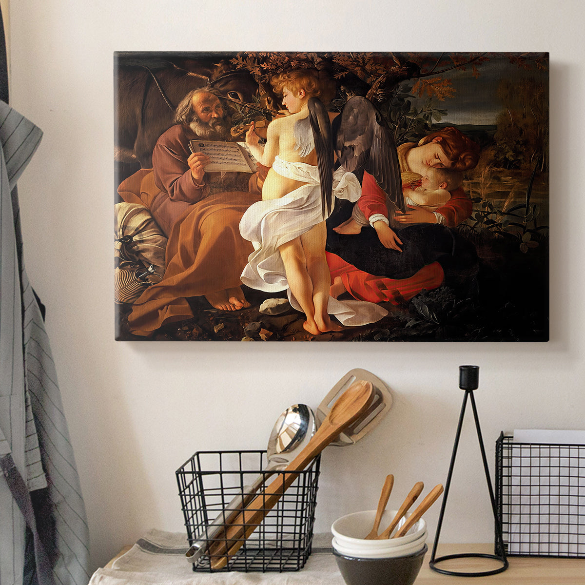 Canvas art print detailing a Baroque landscape with angel playing music for resting travelers, displayed in a softly lit workspace setting