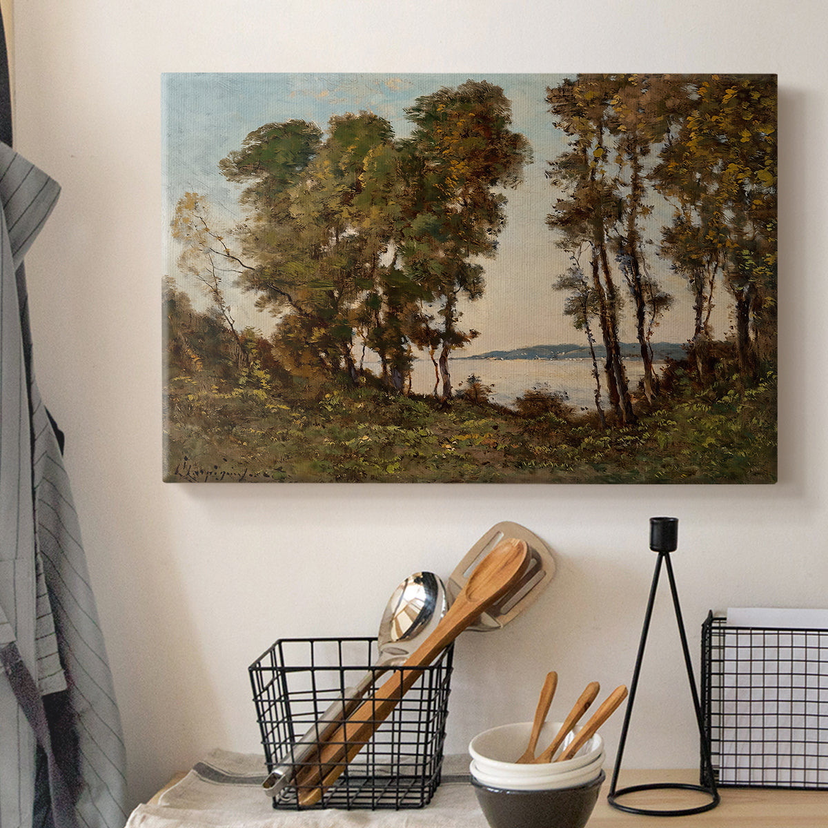 Canvas art print detailing a countryside setting with river and tree-lined banks, displayed in a softly lit workspace setting