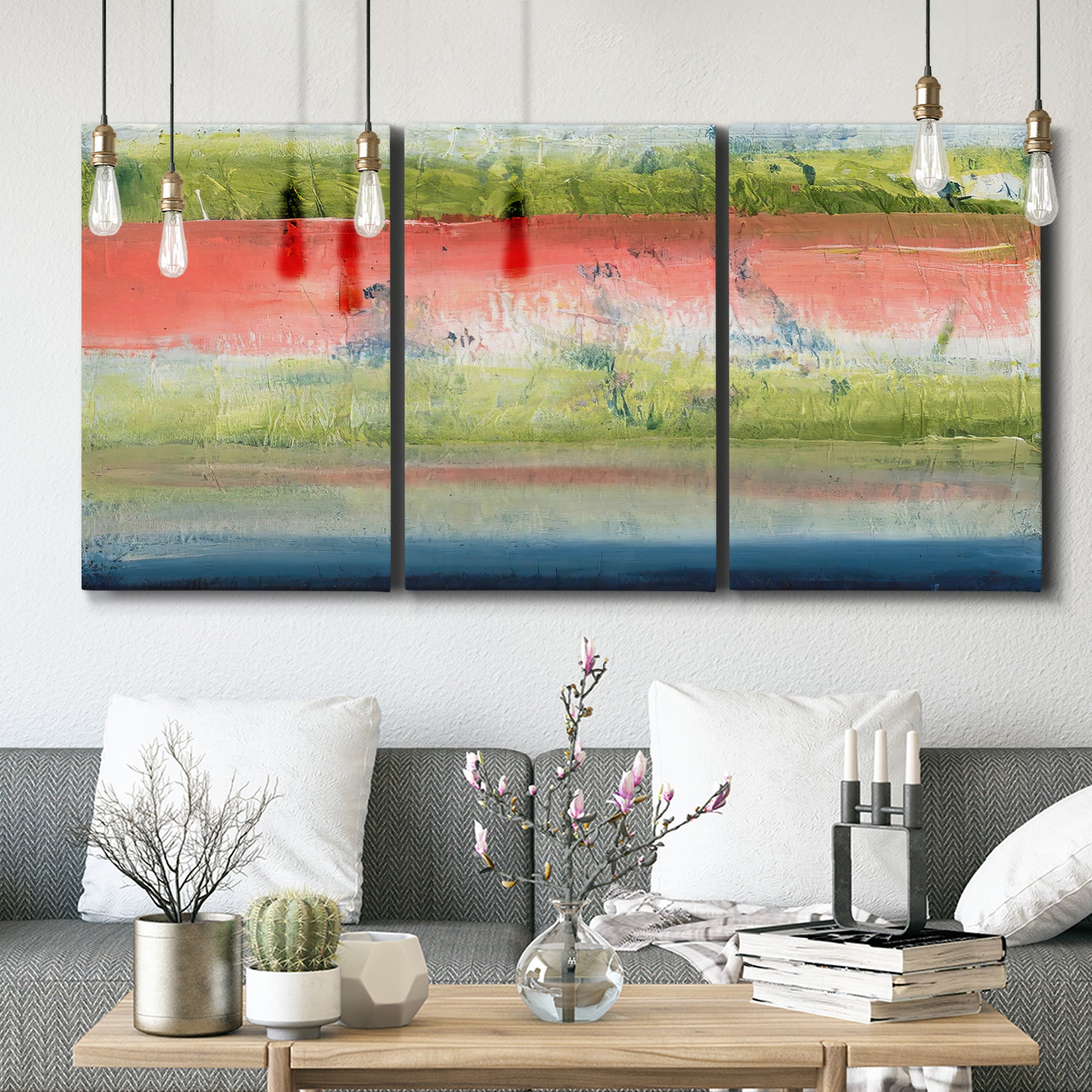 Three-panel canvas wall art featuring layered abstract color banding, displayed in a modern living room above seating.