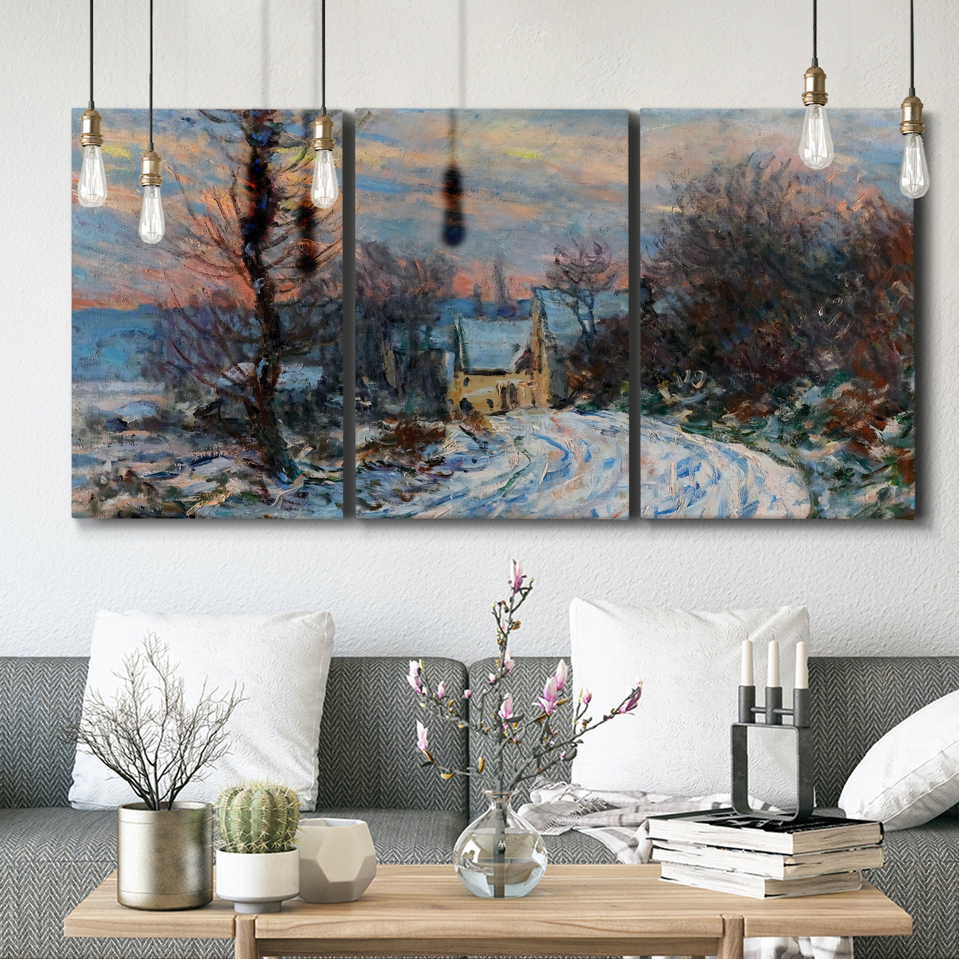 Three-panel canvas wall art featuring snow covered road leading to village, displayed in a modern living room above seating.