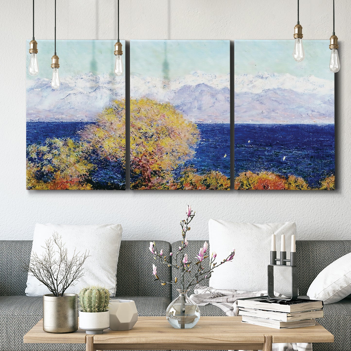 Three-panel canvas wall art featuring mediterranean coastline with headland, displayed in a modern living room above seating.