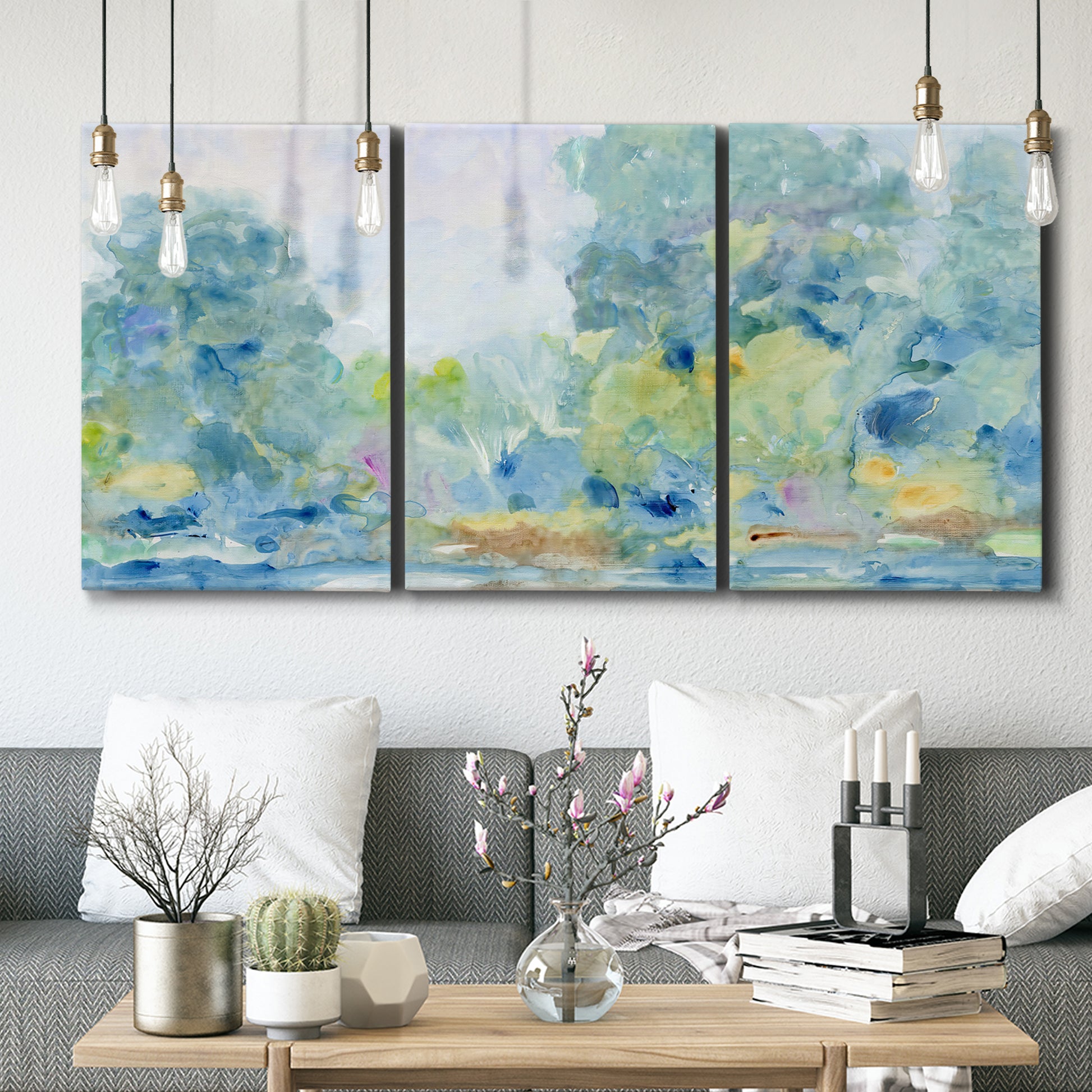 Three-panel canvas wall art featuring quiet abstract morning landscape, displayed in a modern living room above seating.