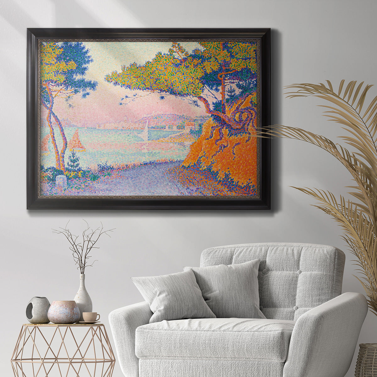 Pointillist coastal seascape by Paul Signac in an ornate black frame with gilded inner detail displayed in a bright interior setting.
