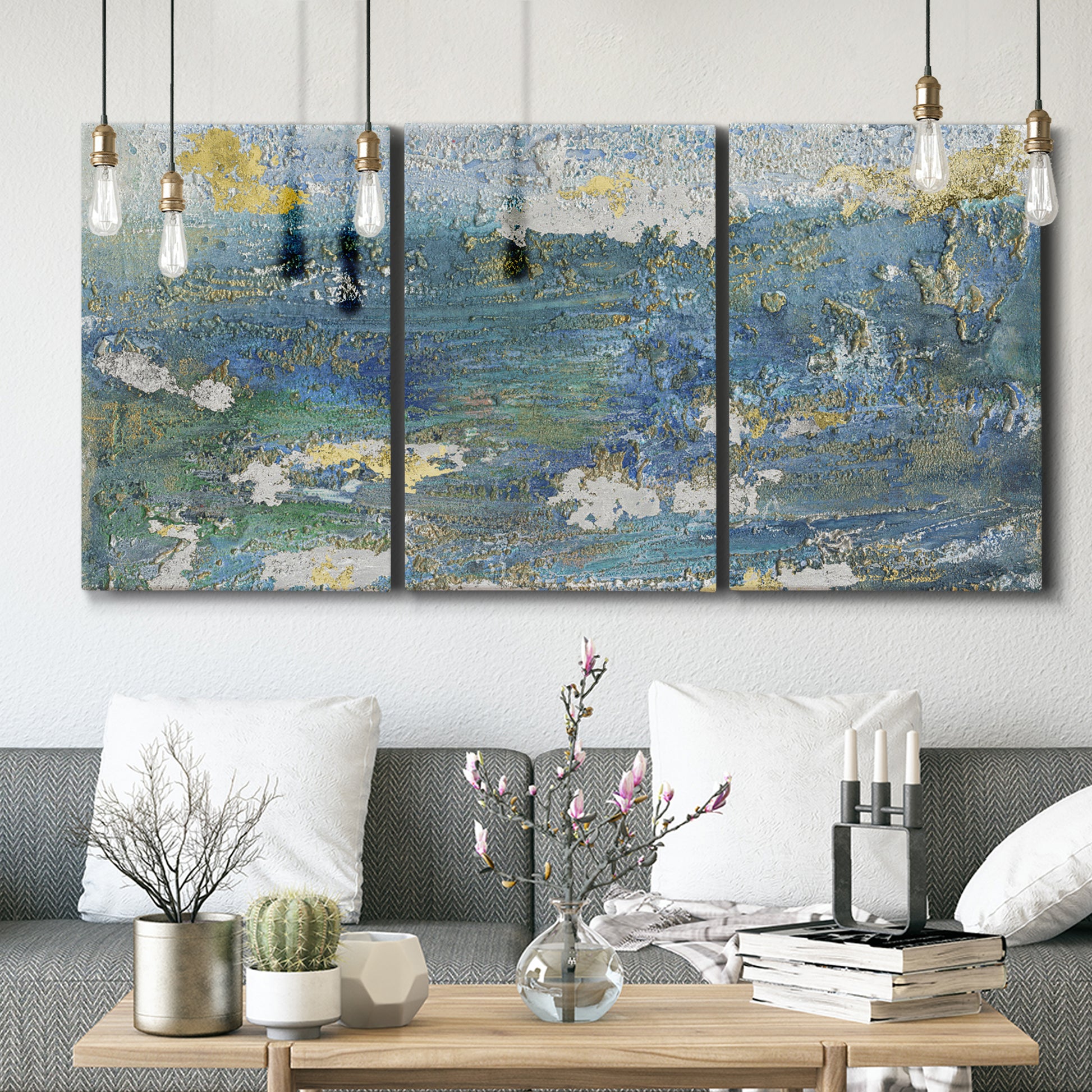 Three-panel canvas wall art featuring sparkling abstract sea surface, displayed in a modern living room above seating.