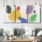 Three-panel canvas wall art featuring inkblot style abstract color symmetry, displayed in a modern living room above seating.