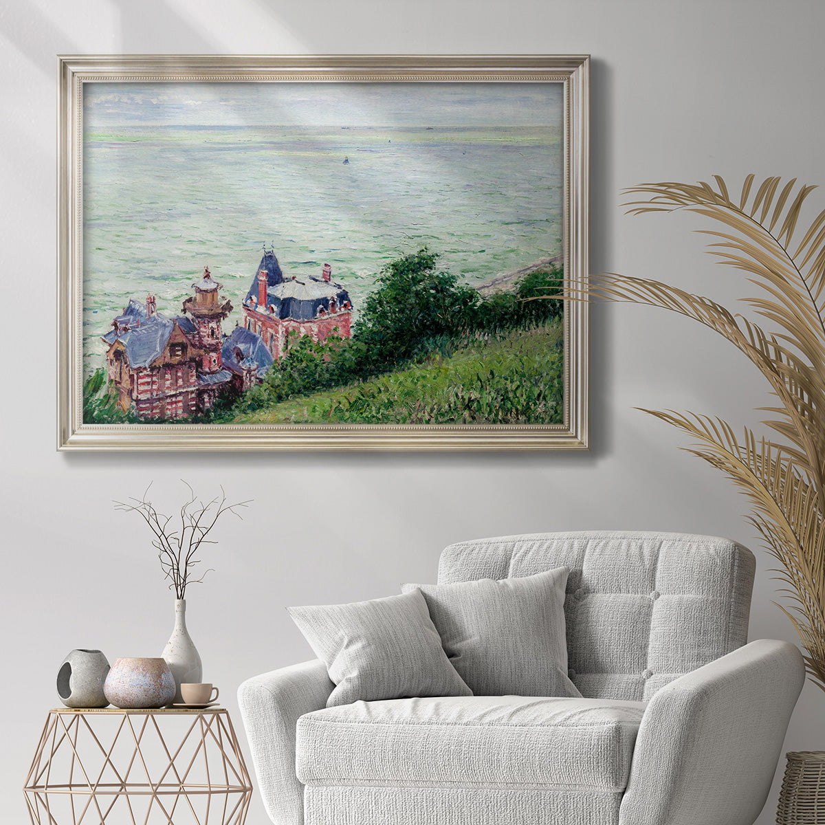 Impressionist coastal villas landscape by Gustave Caillebotte in an ornate champagne frame displayed in a bright interior setting.