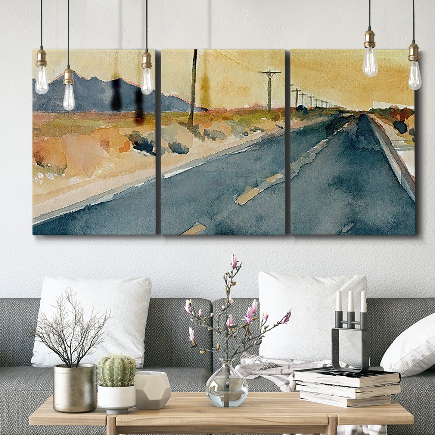 Three-panel canvas wall art featuring empty highway stretching through landscape, displayed in a modern living room above seating.