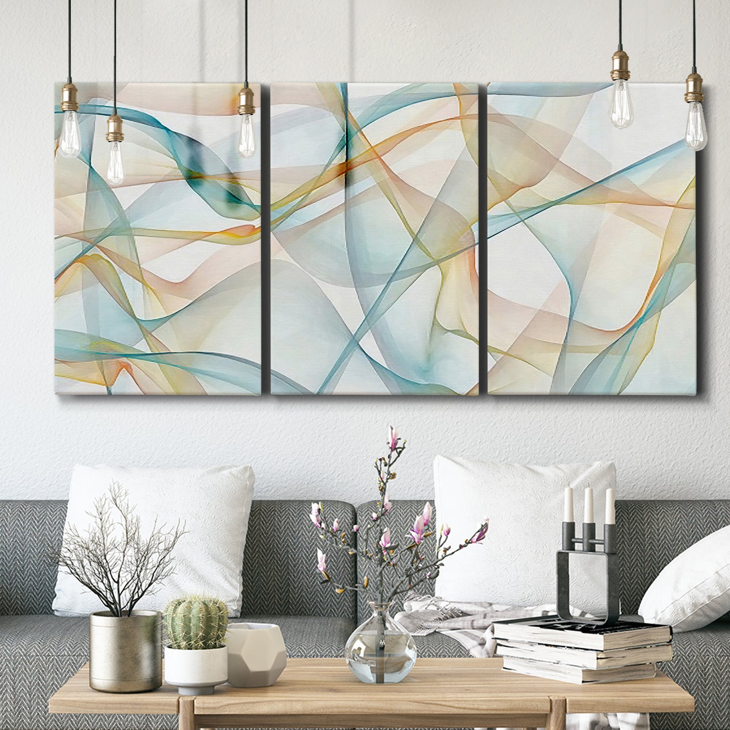 Three-panel canvas wall art featuring flowing abstract curves and wave patterns, displayed in a modern living room above seating.