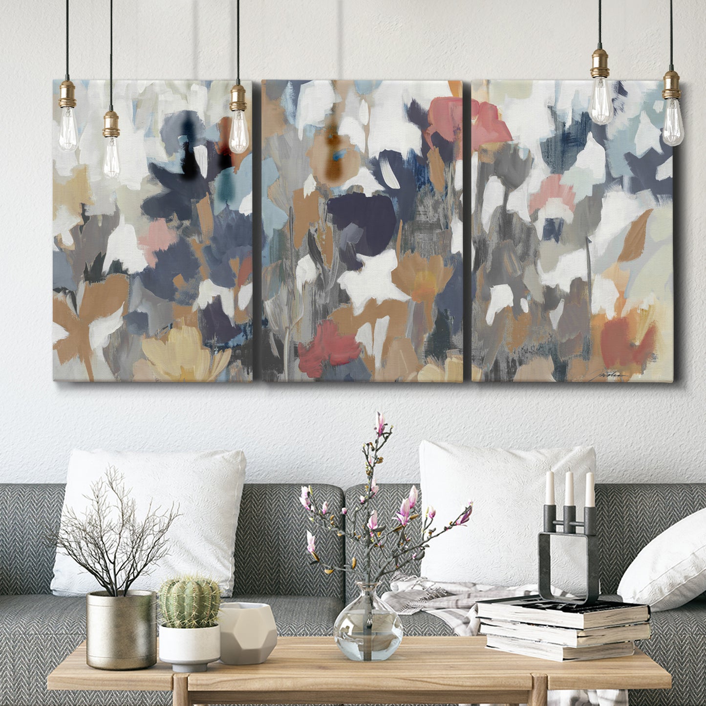 Three-panel canvas wall art featuring abstract flower stand composition, displayed in a modern living room above seating.