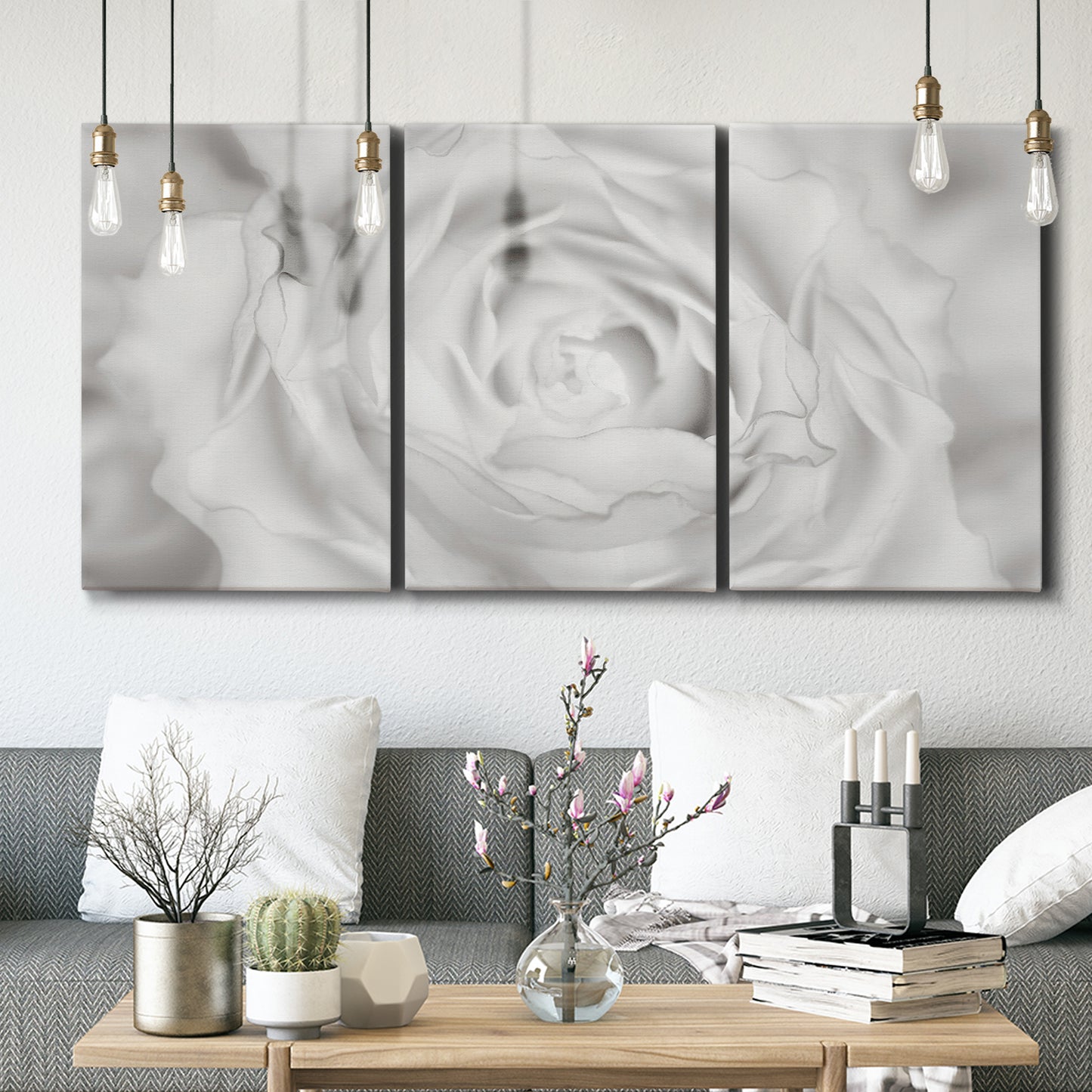 Three-panel canvas wall art featuring monochrome rose study photograph, displayed in a modern living room above seating.