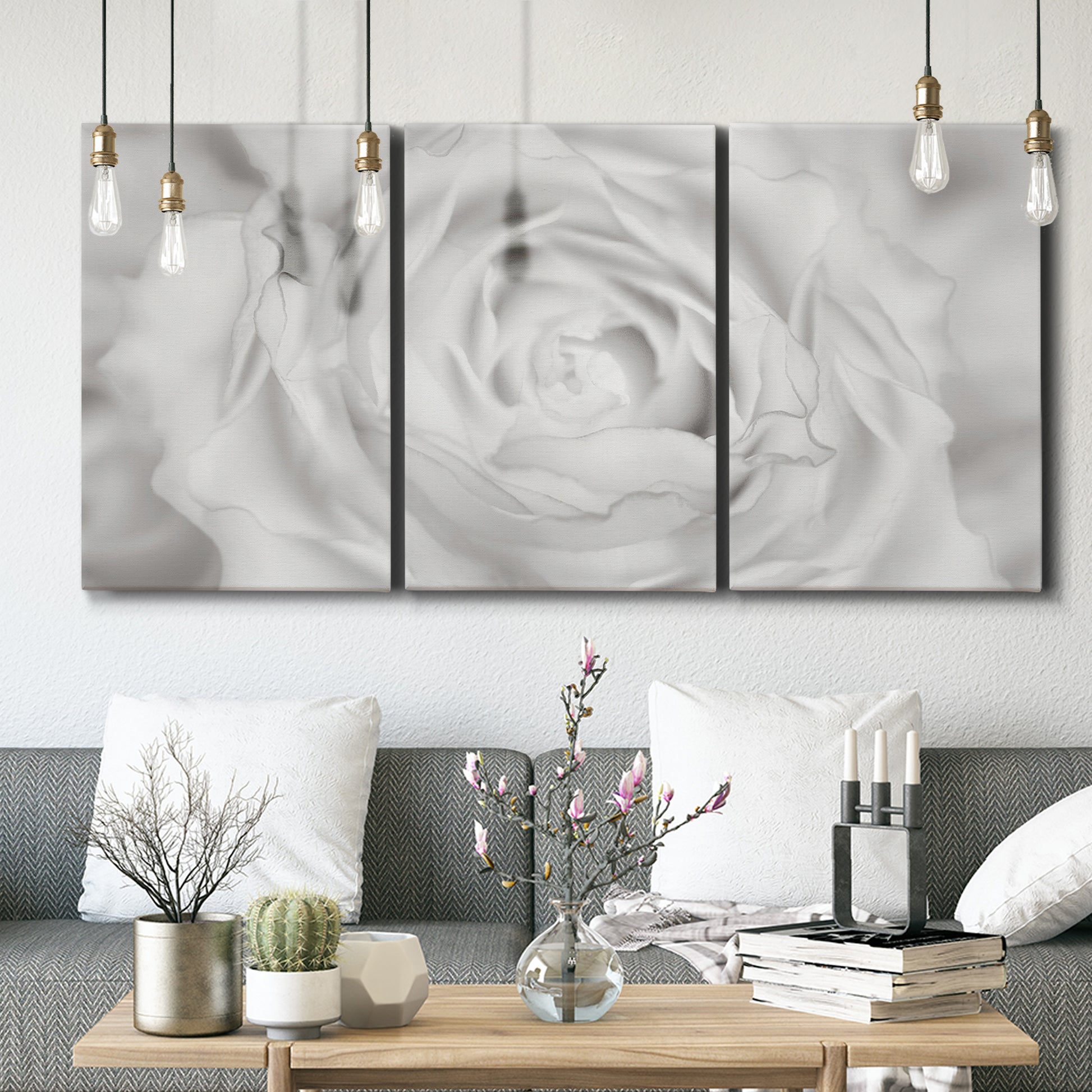 Three-panel canvas wall art featuring monochrome rose study photograph, displayed in a modern living room above seating.