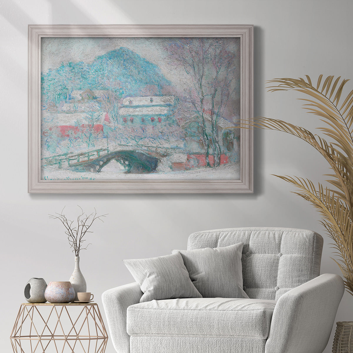 Impressionist coastal village landscape in Norway by Claude Monet in an ornate weathered white frame displayed in a bright interior setting.