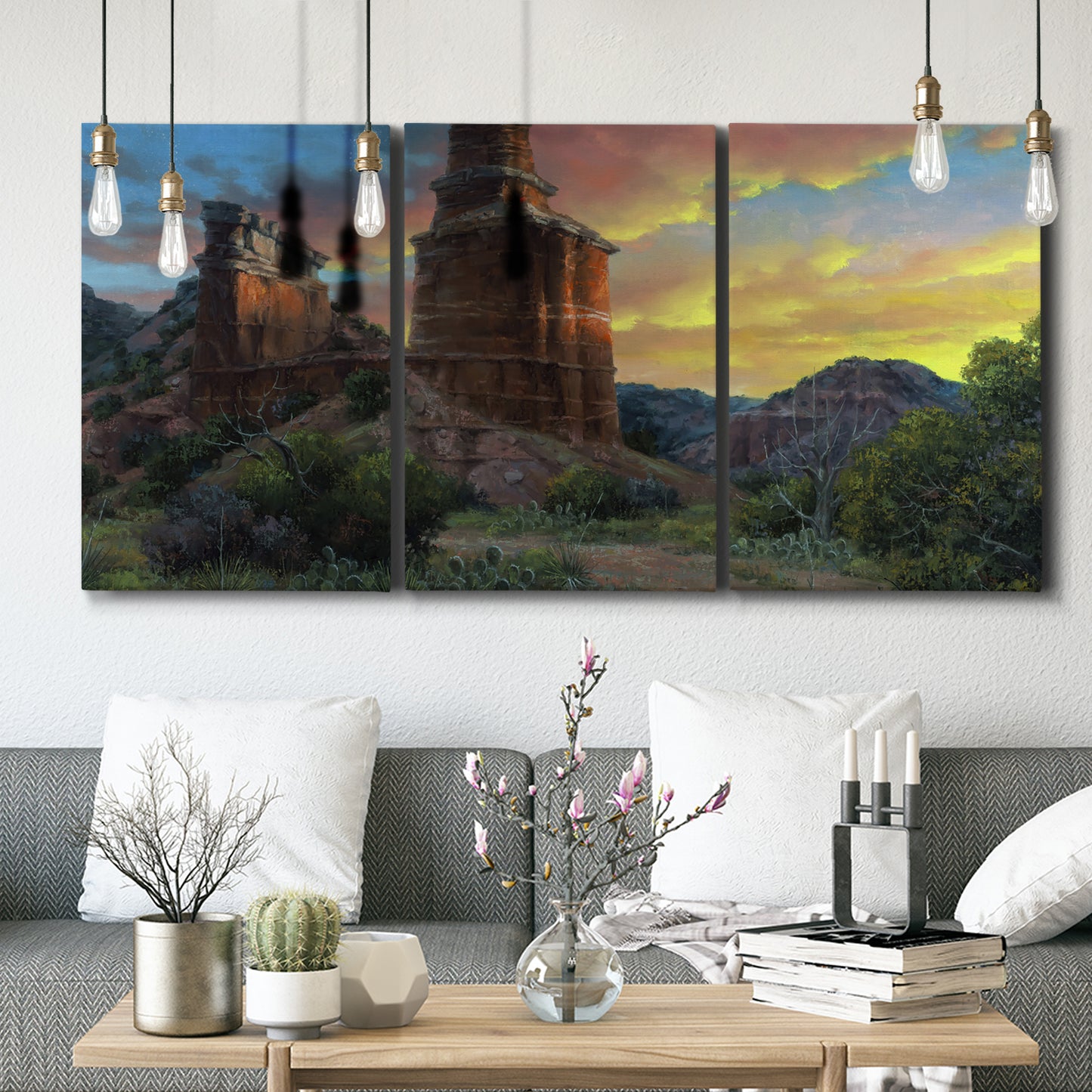 Three-panel canvas wall art featuring dramatic canyon landscape at dusk, displayed in a modern living room above seating.