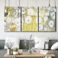 Three-panel canvas wall art featuring vintage inspired floral abstraction, displayed in a modern living room above seating.