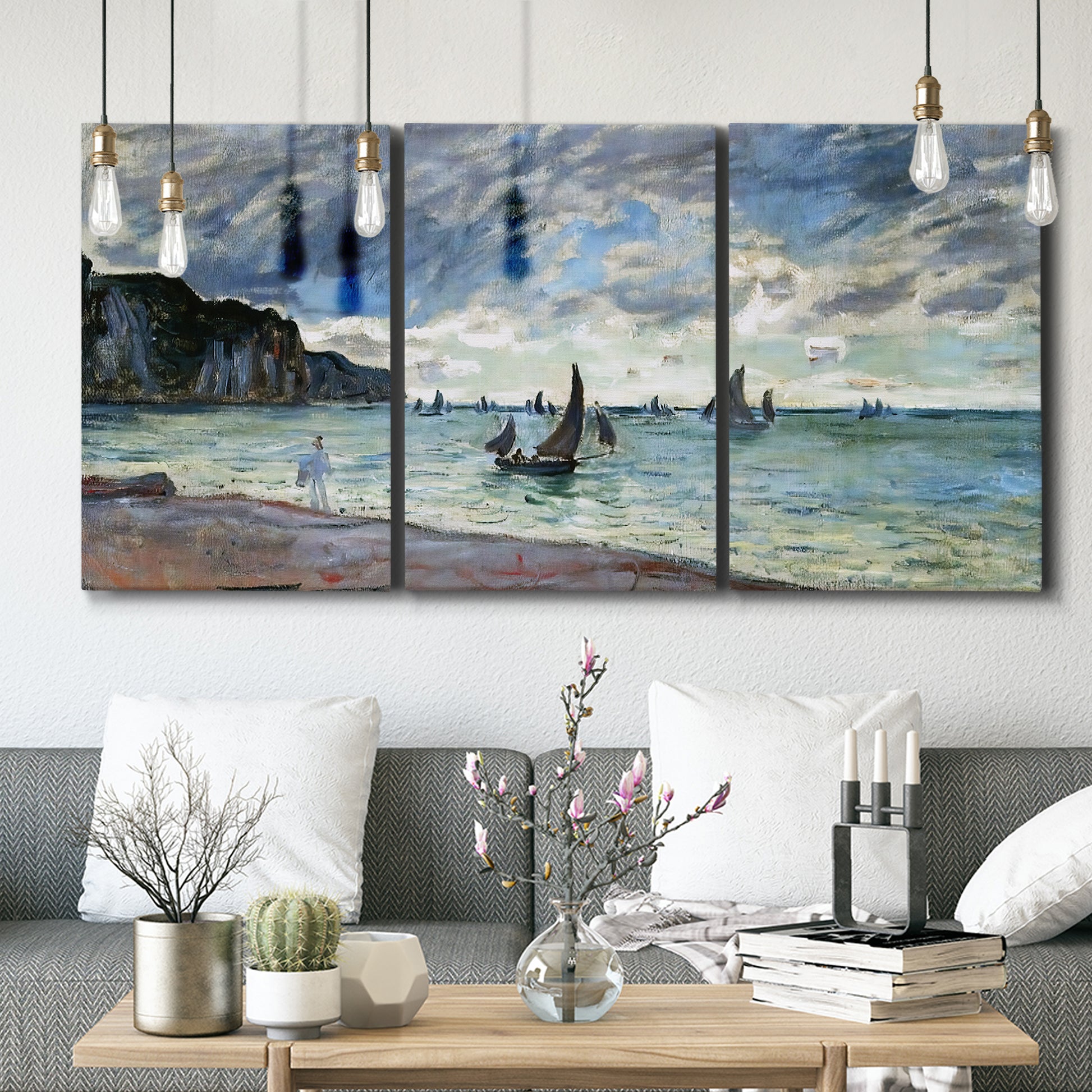 Three-panel canvas wall art featuring figures walking along sandy shoreline, displayed in a modern living room above seating.