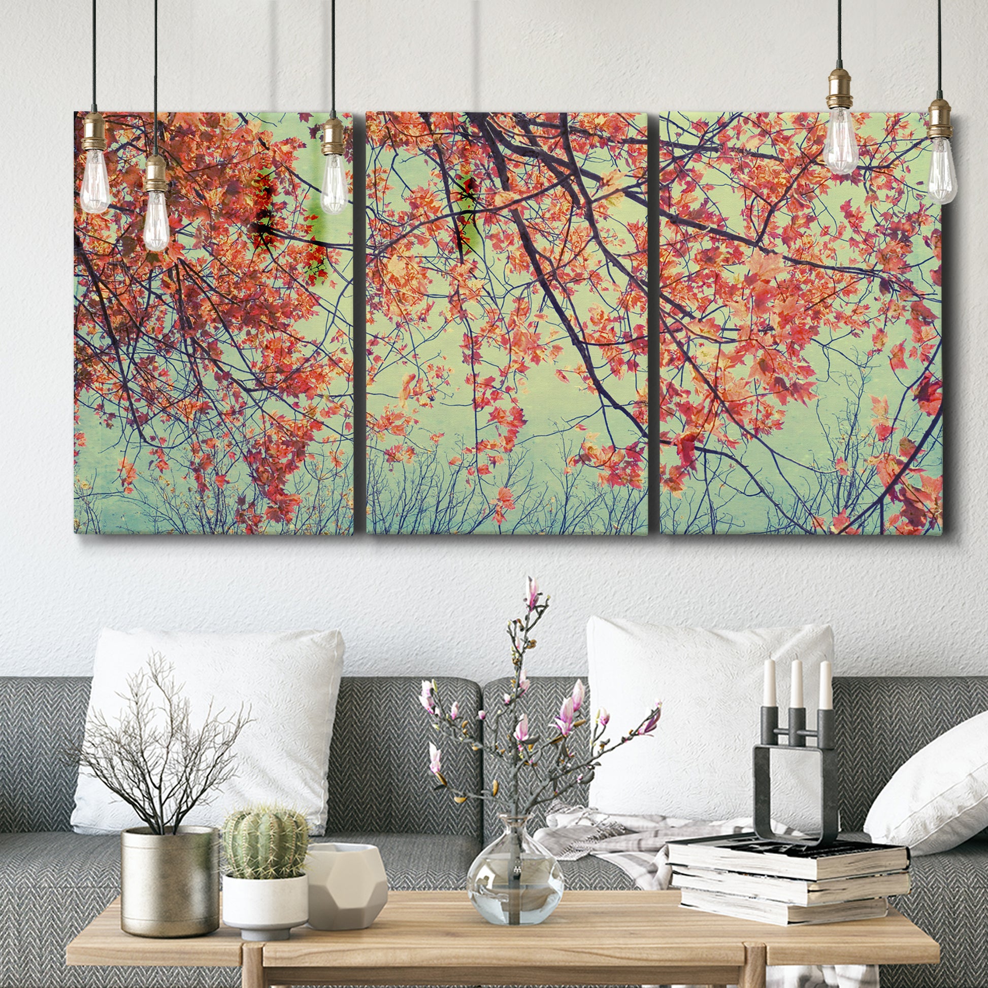 Three-panel canvas wall art featuring autumn foliage landscape photograph, displayed in a modern living room above seating.
