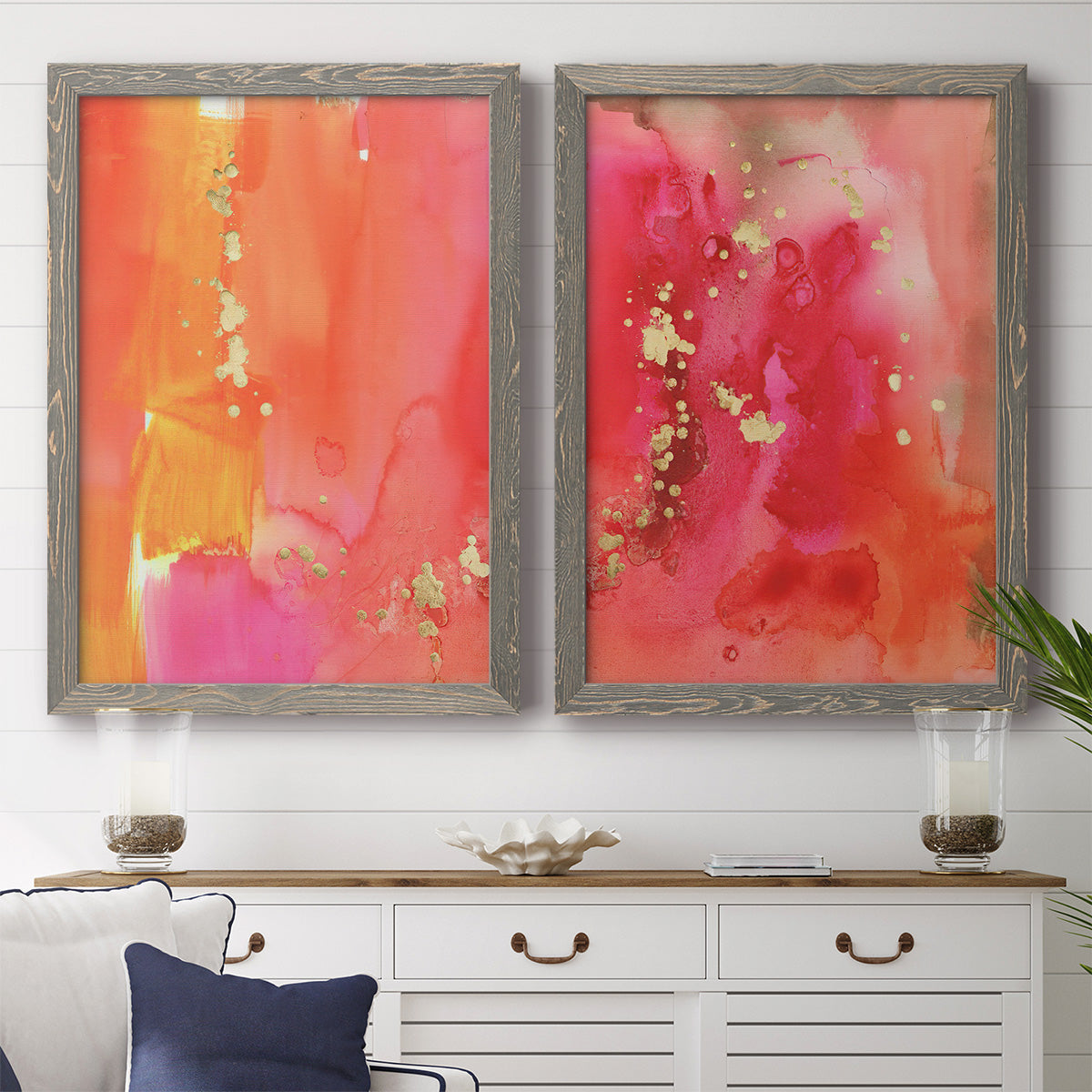 Set of two gray barnwood framed canvas prints depicting a coordinated art pair of luminous coral orange and pink color fields with gold flecks rendered as glamorous fluid abstracts above a dining room sideboard.