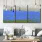 Three-panel canvas wall art featuring abstract coastal inlet landscape, displayed in a modern living room above seating.
