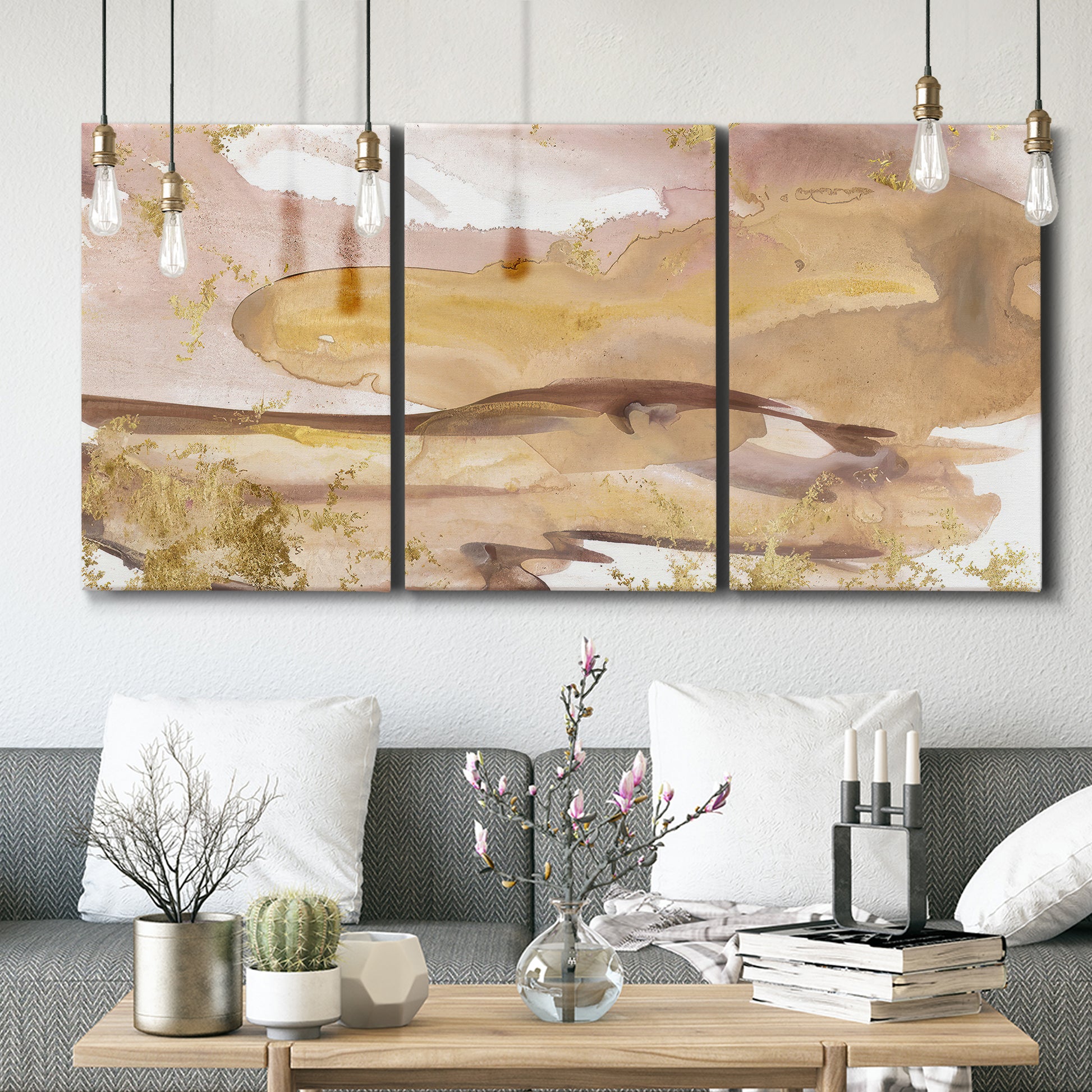 Three-panel canvas wall art featuring layered abstract dawn tones, displayed in a modern living room above seating.