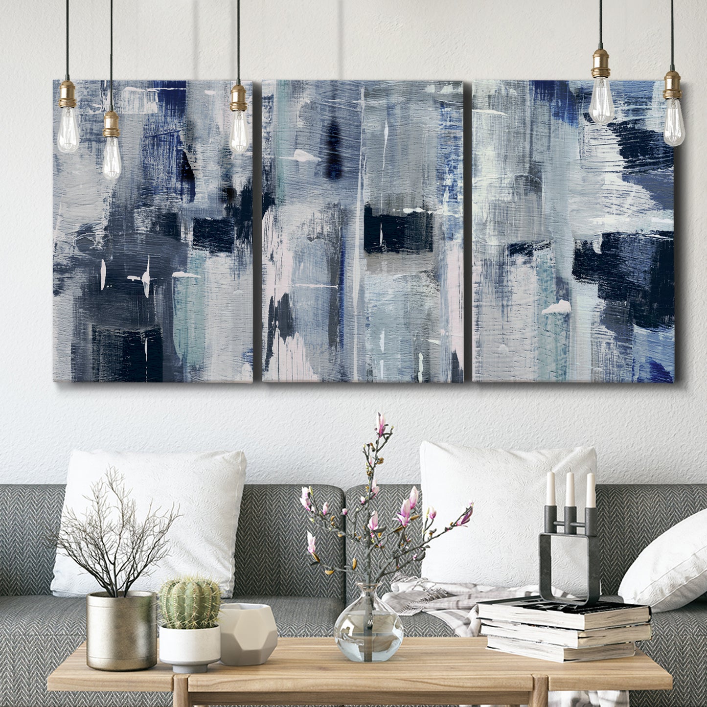 Three-panel canvas wall art featuring soft abstract mountain color fields, displayed in a modern living room above seating.