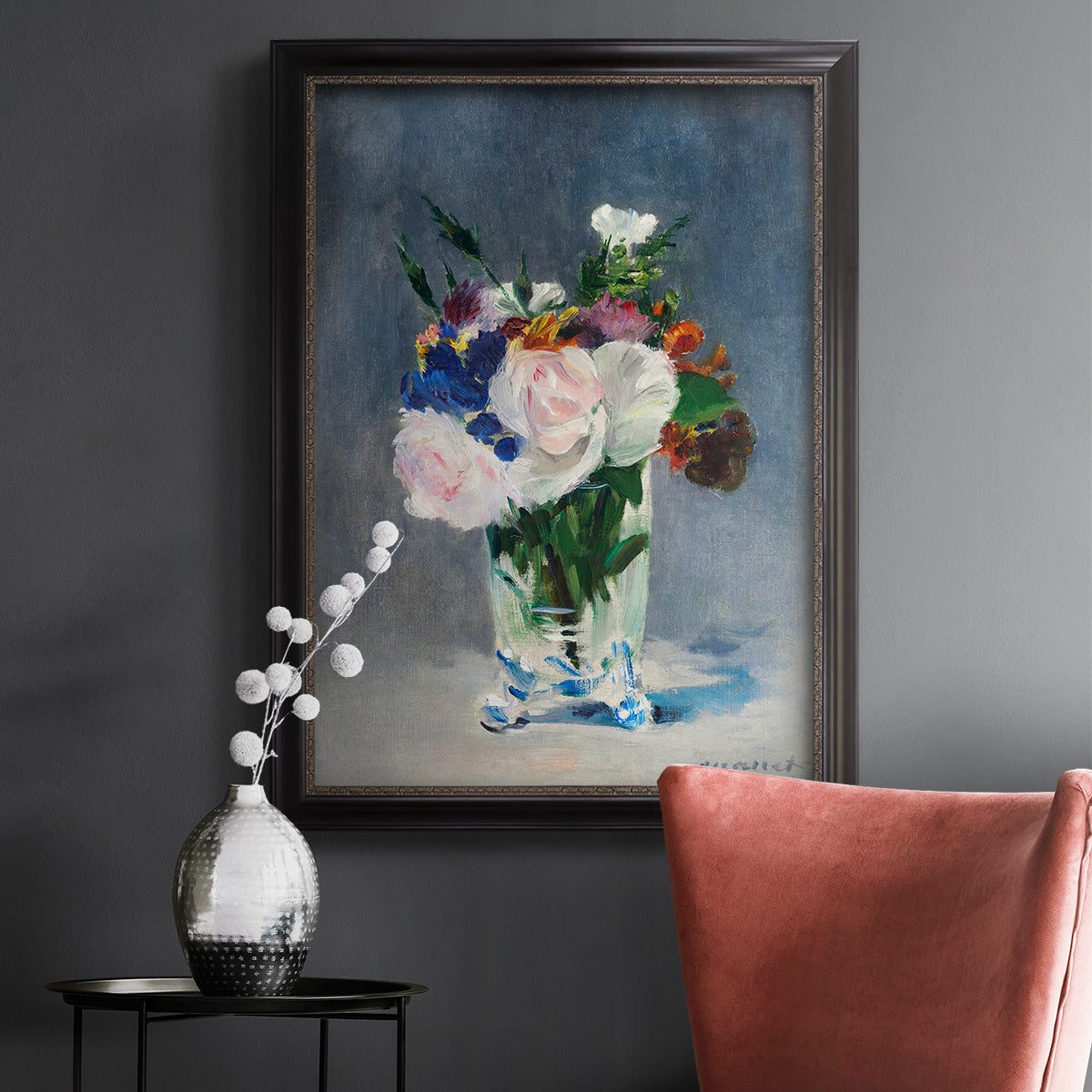 Impressionist floral still life painting by Claude Monet in an ornate black frame with gilded inner detail displayed in a dark-toned interior setting.