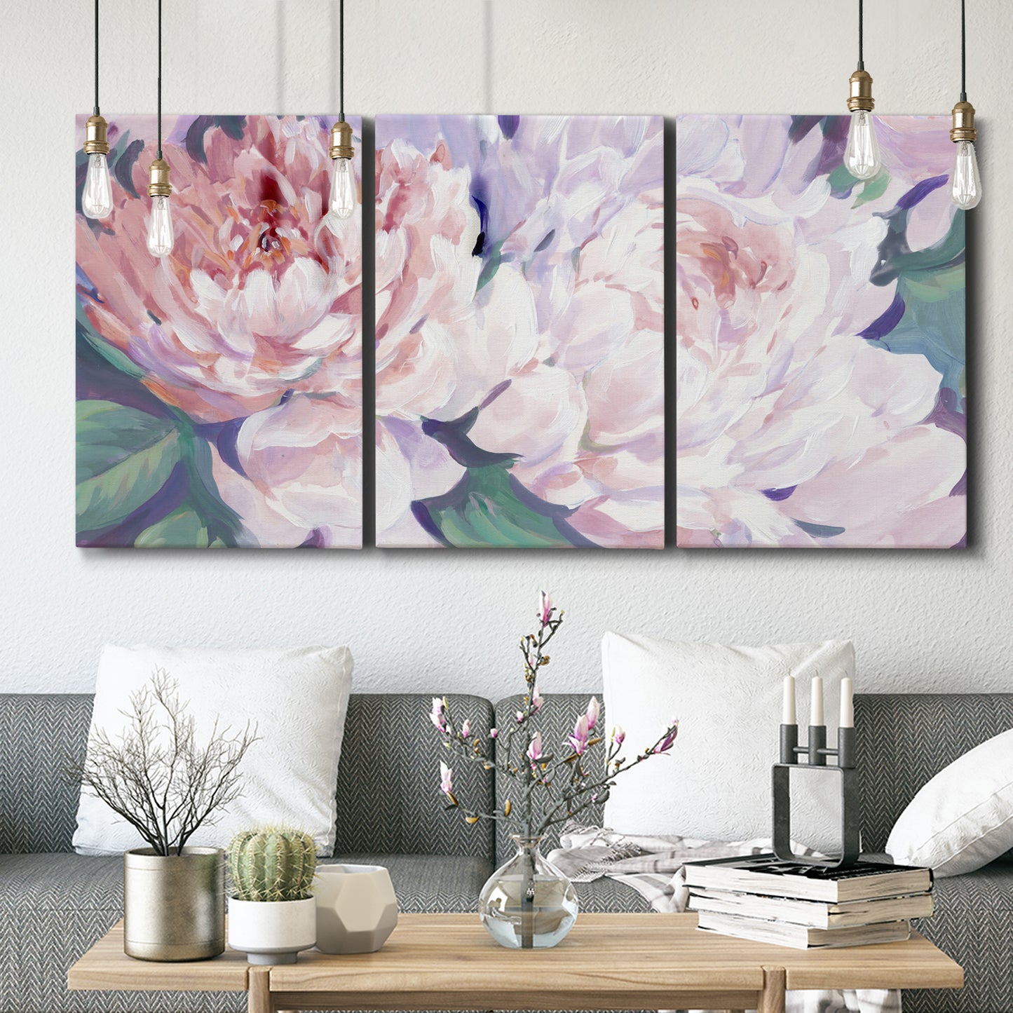 Three-panel canvas wall art featuring soft pink peonies in bloom, displayed in a modern living room above seating.