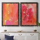 Set of two black barnwood framed canvas prints depicting a coordinated art pair of luminous coral orange and pink color fields with gold flecks rendered as glamorous fluid abstracts above a dining room sideboard.